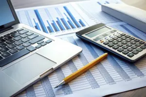 Finance and accounting with reports, laptop and calculator